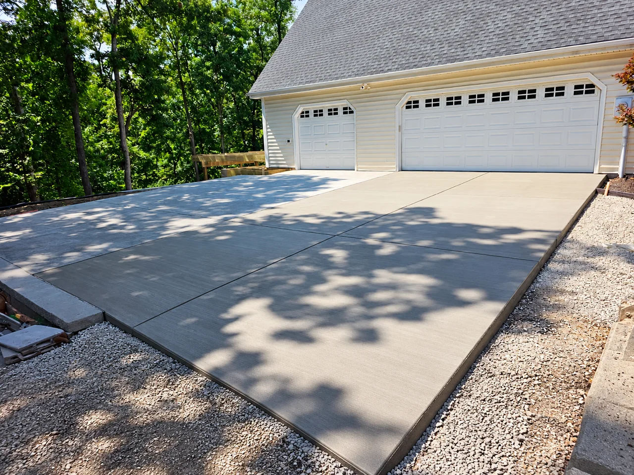 Completed concrete driveway with a two-car garage by STL Hardscape Solutions in Saint Louis
