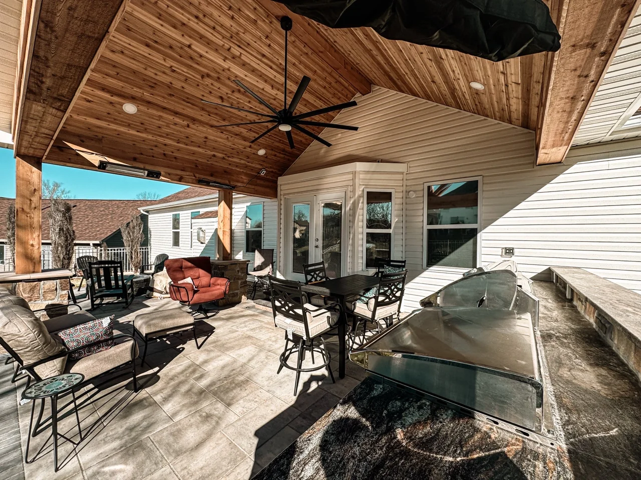 Covered outdoor patio with stone detail and seating in St. Louis