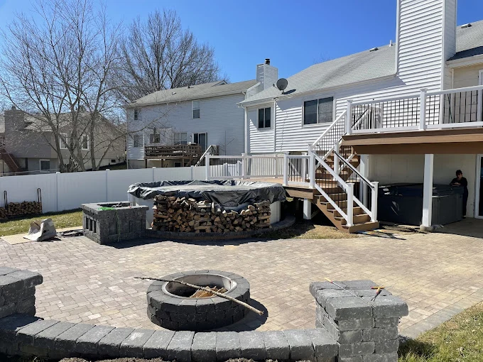 Backyard patio with fire pit and deck - completed hardscape project in St. Louis