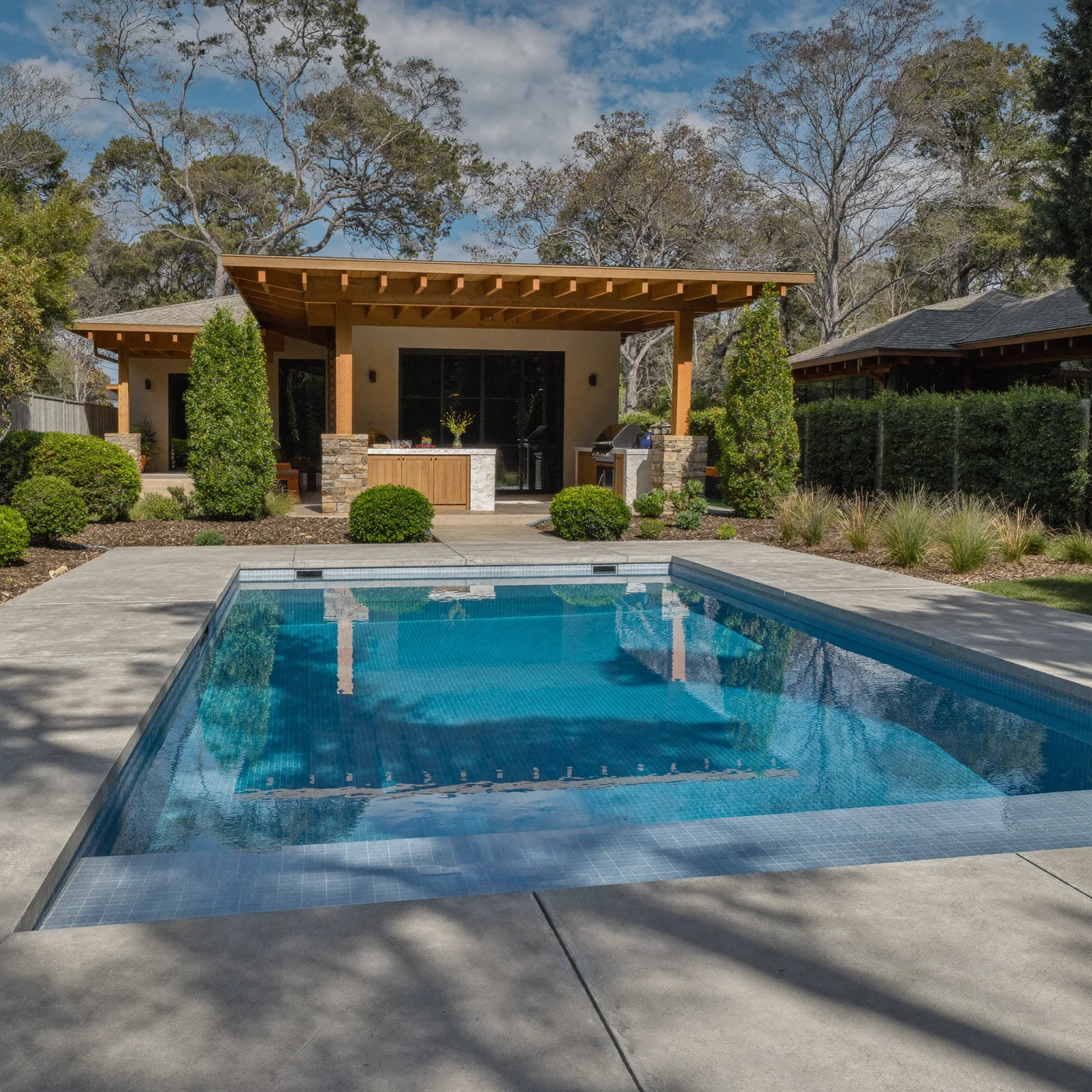Pool with covered outdoor kitchen - completed hardscape project in St. Louis